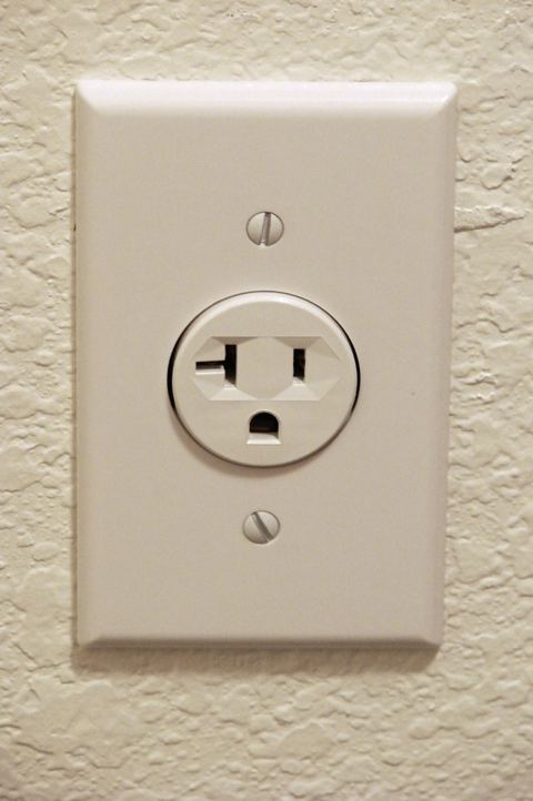 A standard 120V electrical outlet on a textured wall where you can plug a mini split into a regular outlet