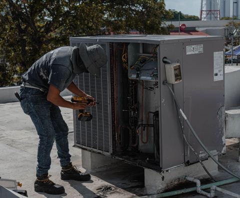 HVAC technician working on rooftop unit with visible electrical wire gauge for 18000 btu mini split wiring