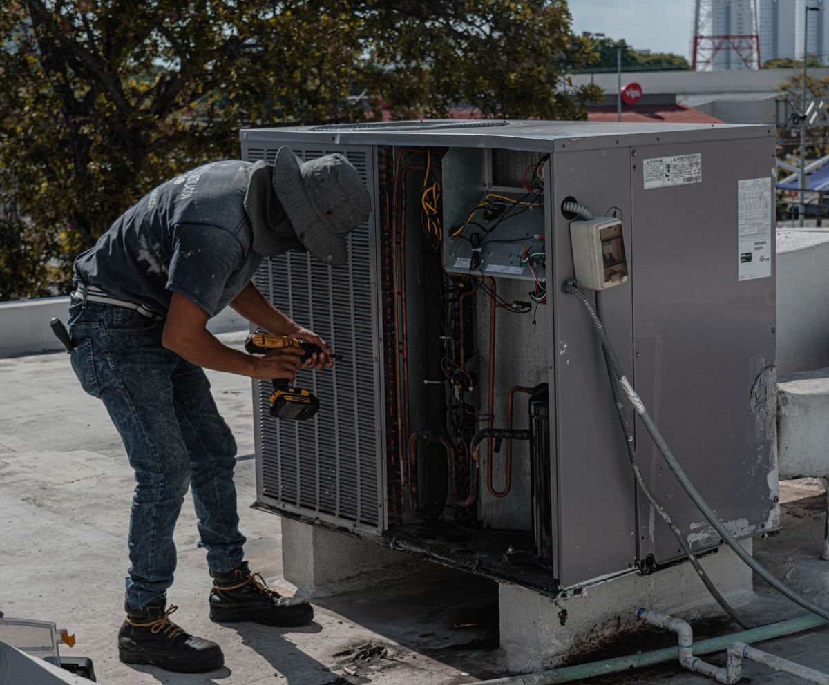 HVAC technician working on rooftop unit with visible electrical wire gauge for 18000 btu mini split wiring
